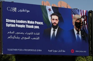 عکس؛ مخدوش کردن تصویر دونالد ترامپ بر روی یک تابلو تبلیغاتی در دمشق